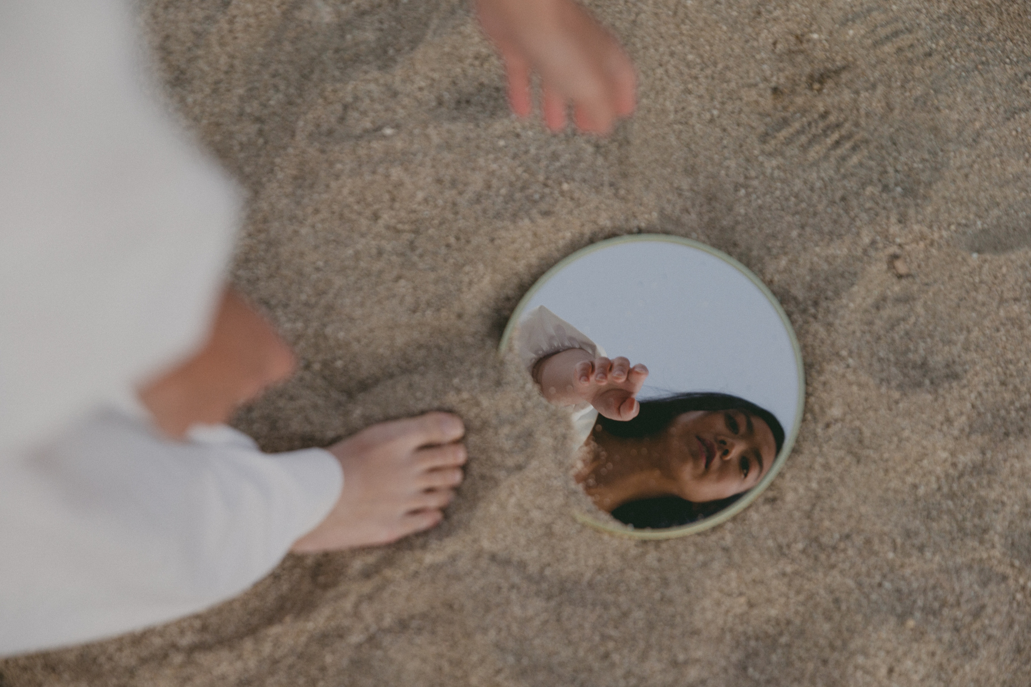 Woman Looking at Compact Mirror at the Beach